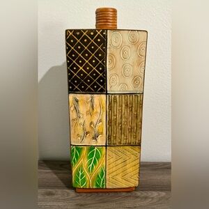 Stylish ceramic vase in the shape of a perfume bottle with a nuanced floral patt